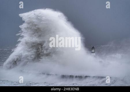 Enormi onde si scontrano contro il faro di Seaham Harbour, County Durham, alla fine della coda di Storm Arwen che ha visto raffiche di quasi 100 miglia all'ora in aree devastanti del Regno Unito. Data foto: Sabato 27 novembre 2021. Foto Stock