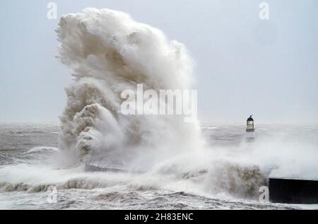 Enormi onde si scontrano contro il faro di Seaham Harbour, County Durham, alla fine della coda di Storm Arwen che ha visto raffiche di quasi 100 miglia all'ora in aree devastanti del Regno Unito. Data foto: Sabato 27 novembre 2021. Foto Stock