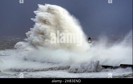 Enormi onde si scontrano contro il faro di Seaham Harbour, County Durham, alla fine della coda di Storm Arwen che ha visto raffiche di quasi 100 miglia all'ora in aree devastanti del Regno Unito. Data foto: Sabato 27 novembre 2021. Foto Stock