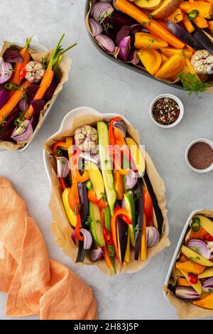 Verdure fresche tritate cucinate al forno in vari piatti di ceramica, vista dall'alto Foto Stock