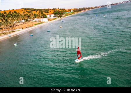 Mui Ne, Vietnam. Man Riproduci wind surf sport in mare sotto il vasto cielo blu. vista dall'alto, vista aerea, Foto Stock