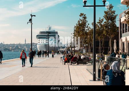 Galataport di Istanbul. Persone che camminano sul molo di Galataport e una nave da crociera sullo sfondo. Istanbul Turchia - 11.13.2021 Foto Stock