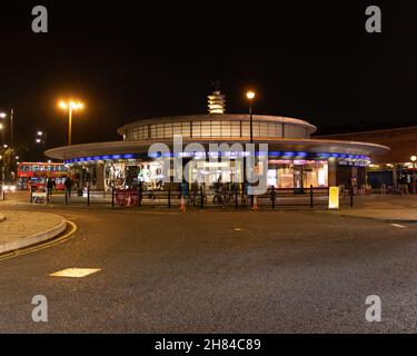 Una foto notturna della stazione della metropolitana di Southgate con la strada in primo piano. La stazione è una stazione Art Deco progettata da Charles Holden. Linea Piccadilly Foto Stock