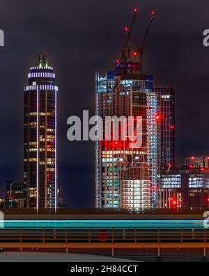 Un treno che arriva alla stazione di Londra con il nuovo sviluppo a Battersea e Nine Elms sullo sfondo. Foto Stock