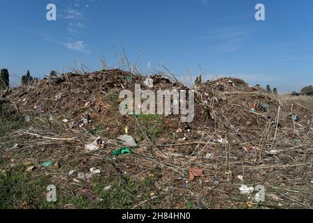 Terreno contaminato da residui industriali, plastica, ferro e nylon Foto Stock