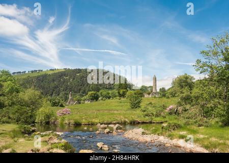 La Chiesa di San Kevin e la Torre rotonda annidate nel bel bosco di Glendalough, Co. Wicklow, Irlanda. Foto Stock
