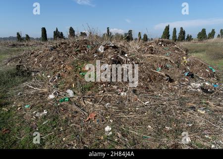 Terreno contaminato da residui industriali, plastica, ferro e nylon Foto Stock