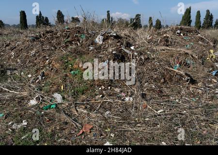 Terreno contaminato da residui industriali, plastica, ferro e nylon Foto Stock