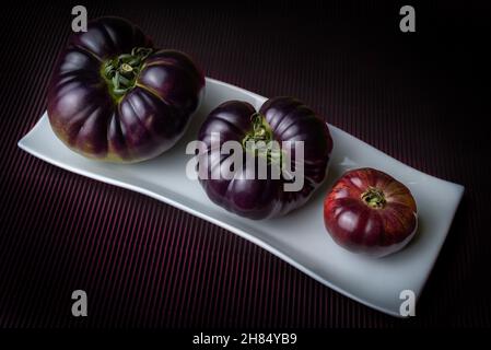 Pomodori della nuova varietà Mar Azul, rosa e bluastro quando maturi, e viola quando ancora verde. Foto Stock