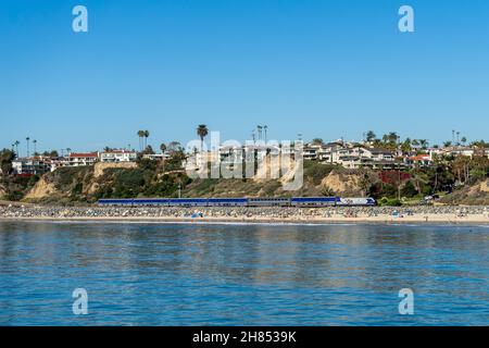 San Clemente, CA, USA – 13 novembre 2021: Il treno Pacific Surfliner della Amtrak viaggia tra San Diego e Los Angeles passando per la spiaggia di San Clement Foto Stock