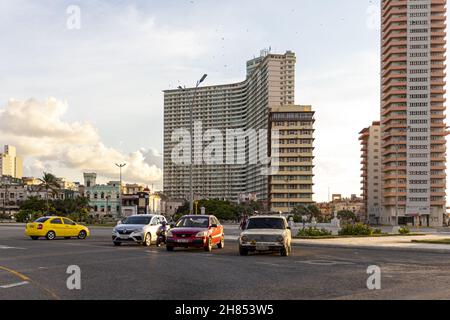 HABANA, CUBA - 29 ottobre 2021: Un gruppo di auto parcheggiate vicino a edifici alti a Vedado, l'Avana Foto Stock