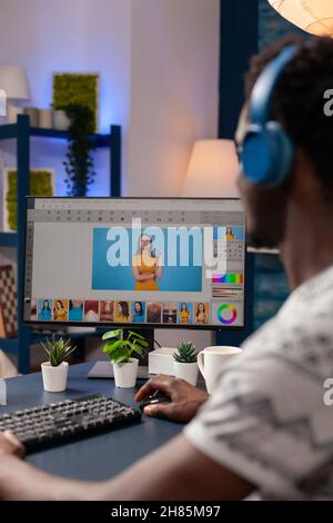 Fotografo di artisti afro-americani con cuffie ritocco foto di designer utilizzando software di post-produzione digitale. Giovane editor illustratore che modifica la fotografia creativa lavorando lontano da casa Foto Stock