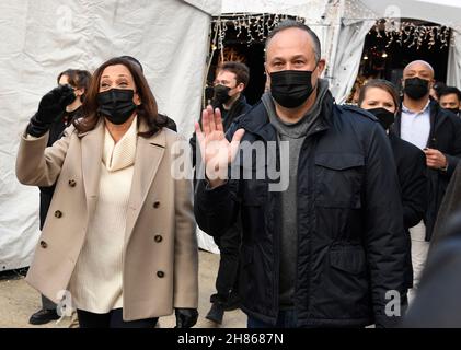 Washington, DC. 27 novembre 2021. Il vicepresidente degli Stati Uniti Kamala Harris (L) e il secondo gentleman Douglas Emhoff fanno l'onda agli acquirenti come sostengono le piccole imprese Sabato con una visita a DCs Downtown Holiday Market, Sabato, 27 novembre 2021, a Washington, CC. Credit: Mike Theiler/Pool via CNP/dpa/Alamy Live News Foto Stock