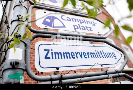 Carolinensiel, Germania. 27 novembre 2021. I cartelli 'Campingplatz' (campeggio) e 'Zimmervermittlung' (agenzia di alloggio) si trovano ad un incrocio nel centro della città. La quarta onda di Corona è anche in movimento attraverso la bassa Sassonia: In vista delle crescenti cifre di infezione, i turisti esitano a prenotare le vacanze di Natale nei monti Harz, sulla brughiera o sulla costa. Credit: Hauke-Christian Dittrich/dpa/Alamy Live News Foto Stock