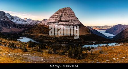 Bear Hat Mountain con copertura innevata, lago nascosto e nebbia protetta McDonald Valley sotto, Glacier National Park, Montana, Stati Uniti Foto Stock