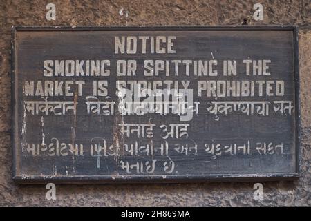 Segno trilingue in inglese, Marathi e Gujarati che proibisce spitting e fumo al Crawford Market (Mahatma Jyotiba Phule Mandai) a Mumbai, India Foto Stock