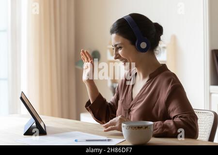 Sorridente giovane indiana che tiene una videochiamata incontro. Foto Stock