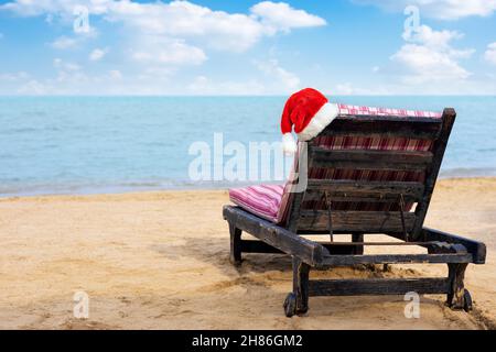 Santa Hat sulla sedia lounge sulla spiaggia di mare Foto Stock
