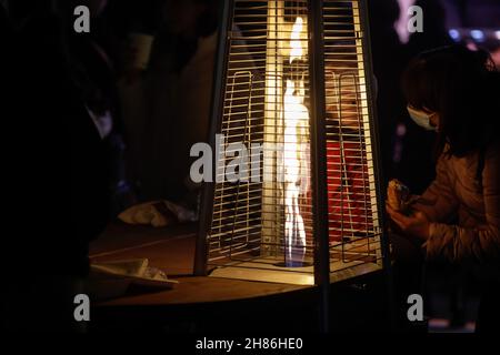 Dettagli con una torre fiamma patio riscaldamento durante una notte fredda. Foto Stock