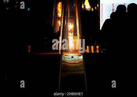 Dettagli con una torre fiamma patio riscaldamento durante una notte fredda. Foto Stock