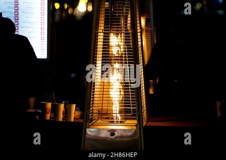 Dettagli con una torre fiamma patio riscaldamento durante una notte fredda. Foto Stock