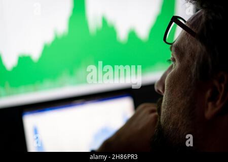 Crypto trader investitore analista guardando computer screen , pensando al mercato azionario online negoziazione rischi globali di investimento. Foto Stock