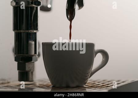 estrazione dell'espresso con portafiltro a beccuccio singolo dal primo piano della macchina da caffè, messa a fuoco poco profonda Foto Stock