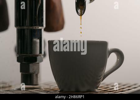 estrazione dell'espresso con portafiltro a beccuccio singolo dal primo piano della macchina da caffè, messa a fuoco poco profonda Foto Stock