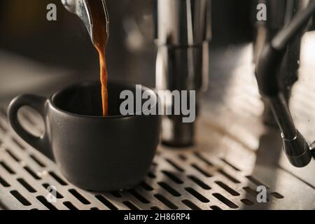 estrazione dell'espresso con portafiltro a beccuccio singolo dal primo piano della macchina da caffè, messa a fuoco poco profonda Foto Stock