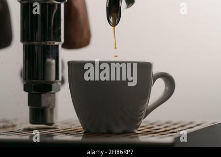 estrazione dell'espresso con portafiltro a beccuccio singolo dal primo piano della macchina da caffè, messa a fuoco poco profonda Foto Stock