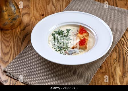 Zuppa cremosa con salmone e crostini con caviale rosso Foto Stock