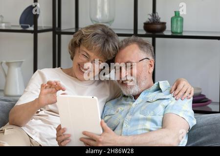 Coppia matura e allegra di pensionati che riposano sul divano a casa Foto Stock