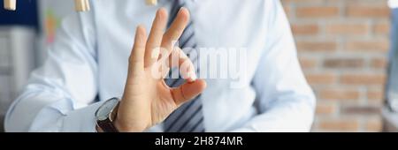 Uomo d'affari in causa che tiene il lotto delle fatture del dollaro nelle sue mani e che mostra il closeup del gesto di ok Foto Stock