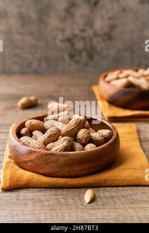 Immagine di un mazzo di arachidi in una ciotola su un tavolo di legno Foto Stock