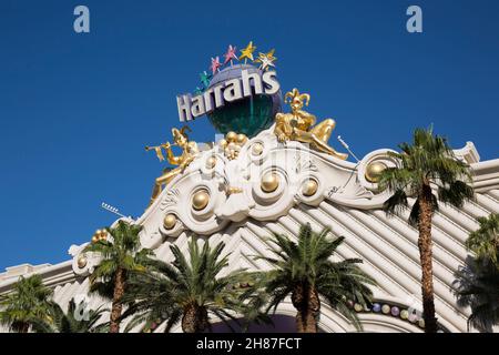 Las Vegas, Nevada, Stati Uniti. Ornamento di carnevale dorato che adorna la facciata superiore dell'Harrah's Las Vegas Hotel and Casino, palme in primo piano. Foto Stock