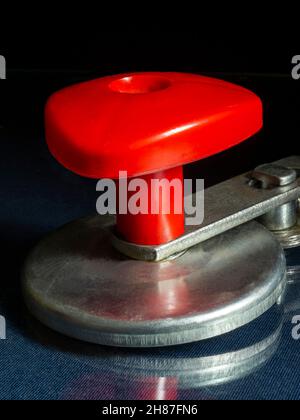 Meccanismo manuale con manico rosso su fondo nero.macchina rotolatrice per vasi di vetro Foto Stock