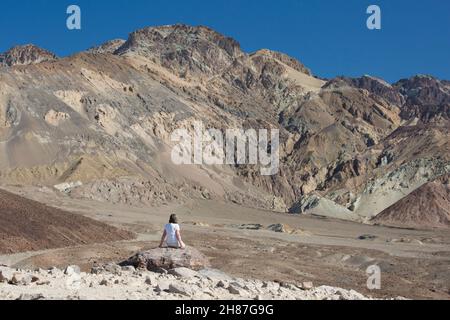 Death Valley National Park, California, USA. Lone visitatore ammirando la vista attraverso l'arido paesaggio del deserto fino alle colorate scogliere della tavolozza degli artisti. Foto Stock