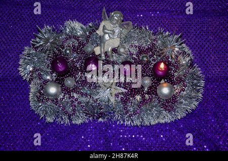 Prima domenica nell'avvento concetto xmas luce viola sfondo con candele palla pallina stells.Studio scatto di un bel wreath avvento con baubles e quattro b Foto Stock