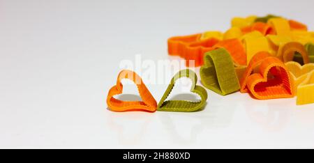 pasta colorata a forma di cuore su sfondo chiaro. Concetto di cibo sano. Messa a fuoco soft Foto Stock