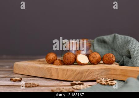 l dolci di Natale tedeschi chiamati 'Marzipankartoffeln'. Pezzi di pasta di mandorle a forma di sfera rotonda ricoperti di cannella e polvere di cacao Foto Stock