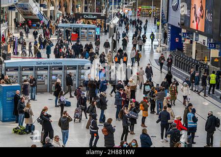 WATERLOO LONDRA, REGNO UNITO. 28 novembre 2021. I viaggiatori che arrivano ad una stazione trafficata di Waterloo la Domenica mattina . Il governo ha annunciato che le facemasks diventeranno obbligatorie sui trasporti pubblici e nei negozi da martedì dopo che i primi due casi del ceppo sudafricano di Omicron sono stati segnalati nel Regno Unito. Credit: amer Ghazzal/Alamy Live News Foto Stock