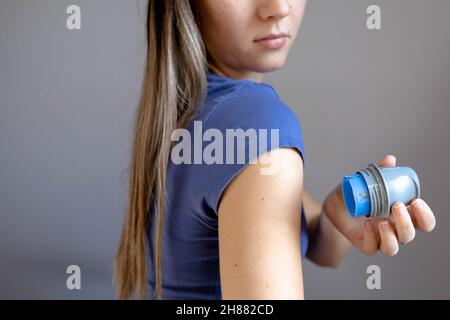 Ragazza che applica il cerotto di monitoraggio del glucosio flash sul braccio Foto Stock