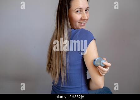 Ragazza che applica il cerotto di monitoraggio del glucosio flash sul braccio Foto Stock