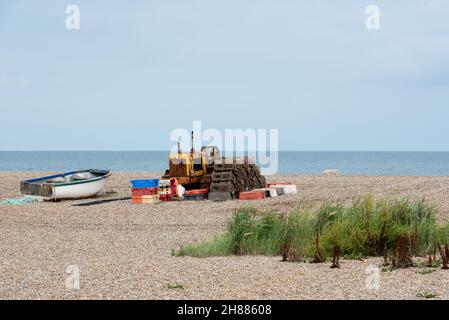 Spiaggia di ciottoli di Cley con barca da pesca, vasi di aragosta e trattore cingolato arrugginito. Agosto, 2021 Foto Stock