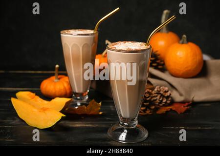 Bicchieri di gustoso latte di zucca su sfondo di legno nero Foto Stock