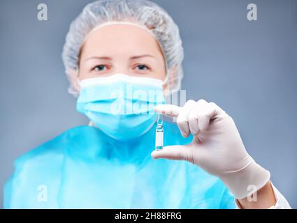 l'infermiera giovane in una maschera medica si pone di fronte alla macchina fotografica su un tema medico Foto Stock