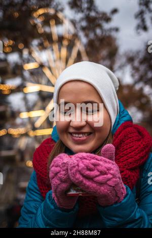 Giovane donna che beve VIN brulé al mercatino di natale di Vienna, Austria. Buon turista godendo la vacanza durante le vacanze di natale. Bevanda calda Foto Stock