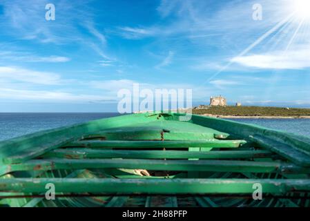 Barche in legno verde di migranti e Mar Mediterraneo a Portopalo di Capo Passero, Isola di Sicilia, Siracusa, Italia, Sud Europa Foto Stock