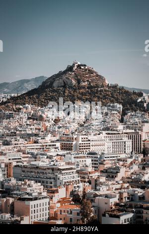 Vista al tramonto del Monte Lycabettus e della città vecchia di Atene dall'Acropoli di Atene. La cima del Monte Lycabettus ha la vetta più alta nel centro di Atene. Foto Stock