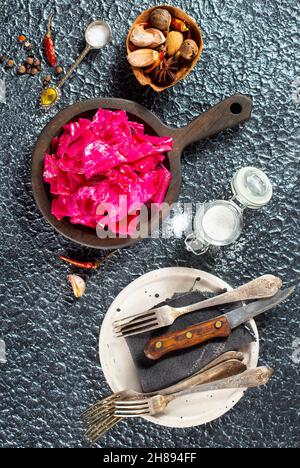 Il cavolo rosso fermentato si trova in un piatto di legno. Crauti con spezie. Orientamento orizzontale. Foto Stock